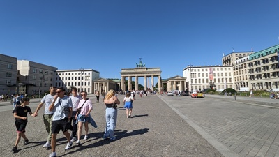 The Brandenburg Gate in the background with tourists in the front square