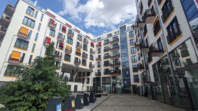 A common apartment block is shown painted white but the windows in red and yellow create a nice picture