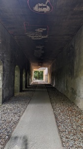 Concrete walls and a concrete ceiling cover a concrete path for pedestrians