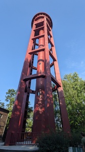 A tall red tower is shown which was used to clean trains with water