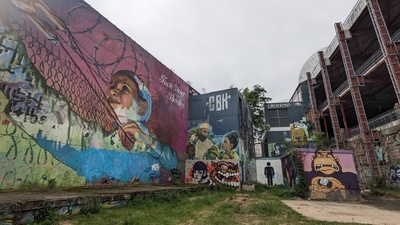 The sides of multiple buildings are shown and several graffiti are visible like a moneky and a boy with a slingshot