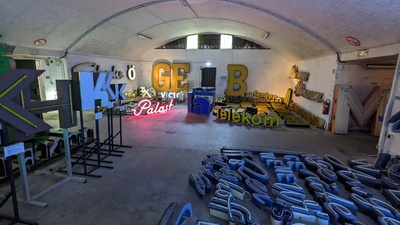 A garage-like room is shown with various letterings on the floor in various sizes exceeding 50cm but with ways between so visitors can still walk along