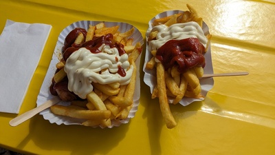 A paper tray with fries and curry wurst