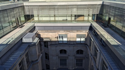 The side of a building is shown and the dropped shadow shows three standing people