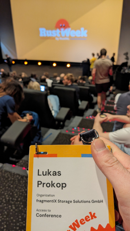 My badge showing my name with a cinema room in the blurred background